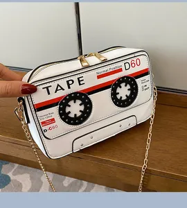 Close-up of a novelty cassette tape crossbody bag featuring a stylish gold chain strap