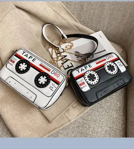 Close-up of retro cassette tape shaped crossbody bags in black and white PU leather