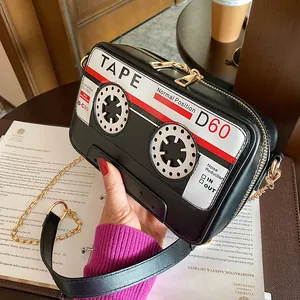 Macro view of quirky cassette tape shaped PU leather crossbody bag with gold chain