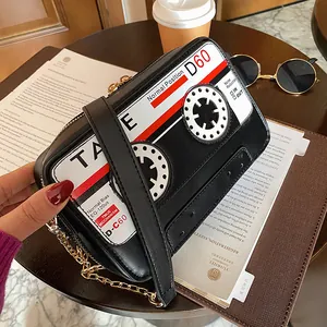Close-up of a stylish retro cassette tape shaped crossbody bag with a gold chain strap