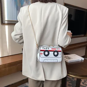 Detail view of retro cassette tape shaped white PU crossbody bag with gold chain strap