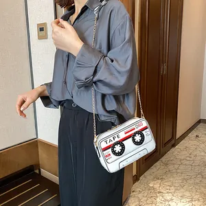 Detailed view of a white cassette tape shaped PU crossbody bag with gold chain strap