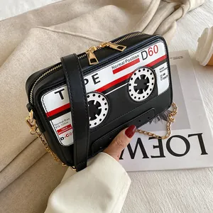Close-up of retro cassette tape shaped PU crossbody bag with golden chain detail