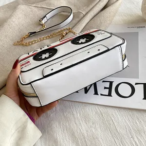 Unique retro cassette tape shaped white crossbody bag with gold chain strap detail