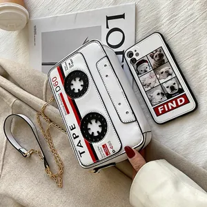 Retro cassette tape shaped crossbody bag in white PU leather with gold chain strap.