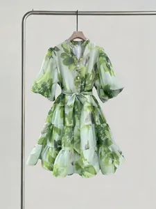 Vista detallada de vestido floral verde con cuello en V, mangas farol y pedrería.