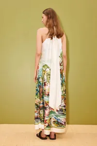 Vista posterior de un vestido maxi suelto con estampado de jungla y lazo blanco al cuello.