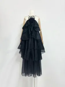 Detail view of a French-style black ruffled maxi dress with a 3D flower halter neck