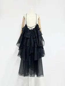 Detailed back view of a black ruffled irregular organza maxi dress with lace-up straps