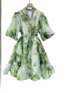 Vestido corto de flores verde con cuello en V, mangas abullonadas y pedrería.