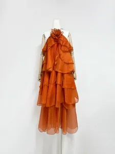 Detail view of orange tiered ruffle maxi dress with 3D floral accent on mannequin