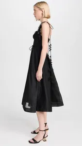 Vue latérale d'une robe caraco noire en soie et lin avec de jolis ornements de pétales.