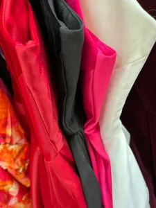 Detailweergave van verschillende elegante off-shoulder jurken in diverse kleuren