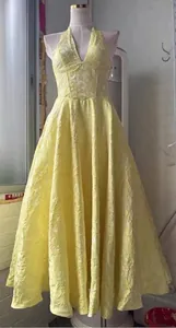 Elegante vestido largo amarillo halter con cuello en V y tejido jacquard floral para fiestas.