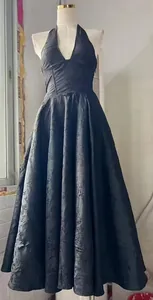 Elegante vestido largo negro con cuello halter, jacquard texturizado y falda de sombrilla