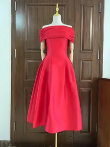 Elegante rode midi-jurk met blote schouders en een wijde rok op een etalagepop