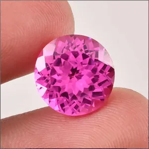 Macro view of a brilliant round-cut lab-grown pink sapphire gemstone with sharp facets