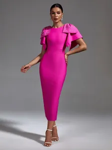 Professional detail of magenta bandage dress featuring oversized pearl-beaded shoulder bows