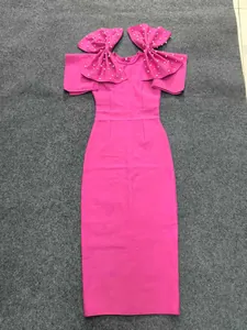 Detail of hot pink bodycon bandage dress featuring large shoulder bows with pearl accents.