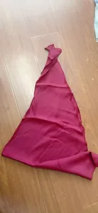 Detailed view of a maroon Renaissance pirate bandana and sash accessory on a wooden floor