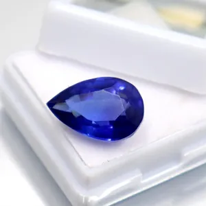 Primer plano detallado de una piedra preciosa de corindón azul oscuro facetada en forma de pera