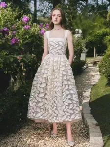 Elegante vestido de malla de estilo francés con bordado de hojas en un jardín.