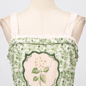 Close-up of floral forest style dress with ruffle square neck and pearl embellishments