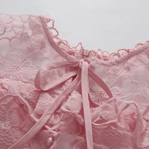 Detailed close-up of a pink lace dress back featuring a bow tie and heart embroidery