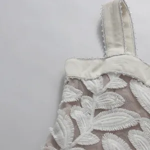 Detalle del bordado de hojas y el empalme de malla en un vestido blanco francés.