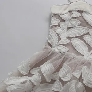 Vista detallada del pesado bordado de hojas blancas en este vestido de gala francés