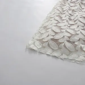 Detalle de bordado de hojas blancas sobre tejido de malla para un vestido de gala francés