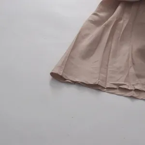 Detalle del dobladillo plisado y costuras finas en un vestido largo de tul beige.