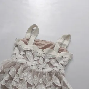 Primer plano detallado del bordado de hojas en vestido de tirantes de malla crema