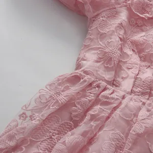 Detailed view of the pink floral lace embroidery on an elegant high-waisted dress.