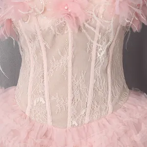 Detail van een elegante roze kanten jurk met korset baleinen en geplooide tule rok