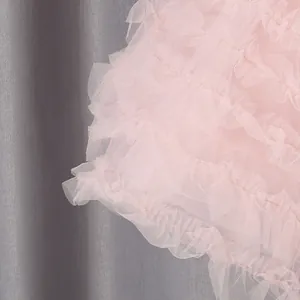Detailopname van roze gelaagde mesh-lagen op een elegante pofrok