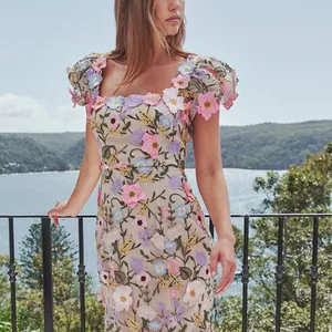 Detail van een elegante Franse jurk met 3D geborduurde bloemen en vierkante hals