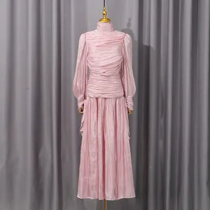 Detalle del elegante vestido largo rosa con fruncidos, manga larga y pliegues