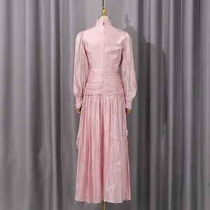 Vista trasera detallada de un vestido largo plisado rosa de manga larga con un suave brillo nacarado