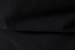 Macro view showing the detailed black cotton linen fabric texture of a men's shirt