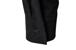Close-up detail of the black cotton linen long sleeve shirt cuff and button texture.
