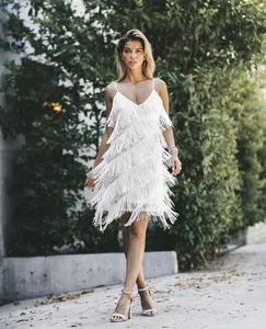 Détail de robe blanche à franges multicouches avec paillettes scintillantes et col en V