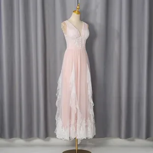 Detail view of an elegant pink maxi dress with intricate white lace trim and V-neck.