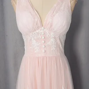 Close-up of elegant pink lace dress featuring a V-neck and delicate white buttons