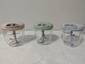 Drei Mini-Hand-Knoblauchzerkleinerer in Pastellrosa, Grün und Blau für die Küche