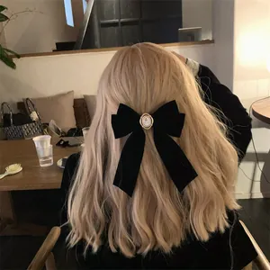 Vue détaillée d'une grande pince à cheveux en velours noir avec rose vintage centrale