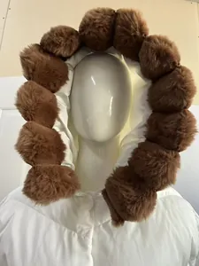 Detailed view of white winter parka featuring a large brown faux fur trim hood
