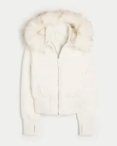 Detail view of white winter puffer jacket with faux fur hood and thumbhole cuffs.