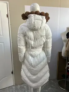 Back view of long white puffer jacket with large brown faux fur hood and waist cinch