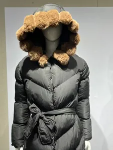 Front view detail of mid-length black puffer coat with large brown faux fur hood and waist tie